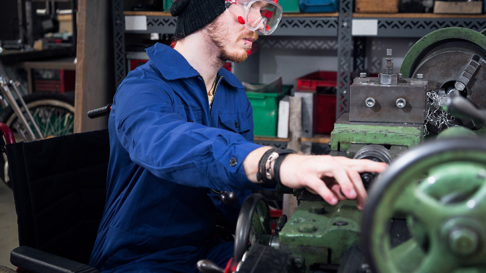 Mechaniker im Rollstuhl an der Drehbank