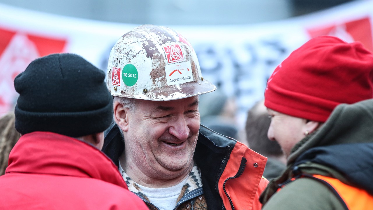 Ein lächenlnder Mann mit weißem Schutzhelm.