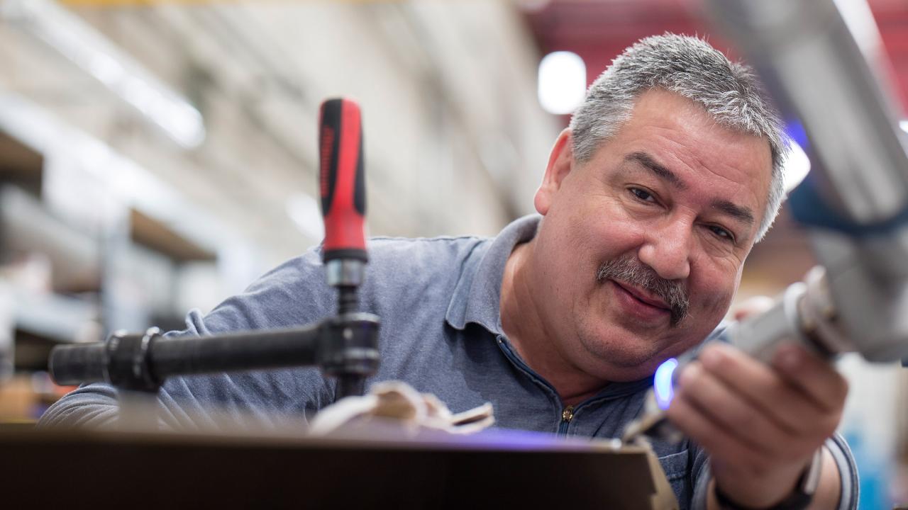 Ein Mann mit einem Werkzeug an einem mechanischen Arm.