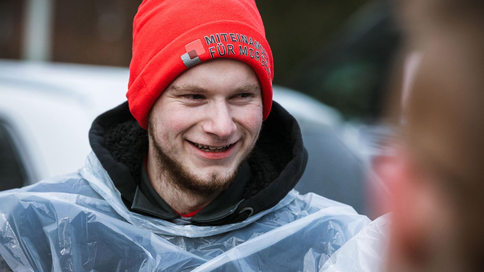 Junger Mann mit roter IG Metall-Mütze