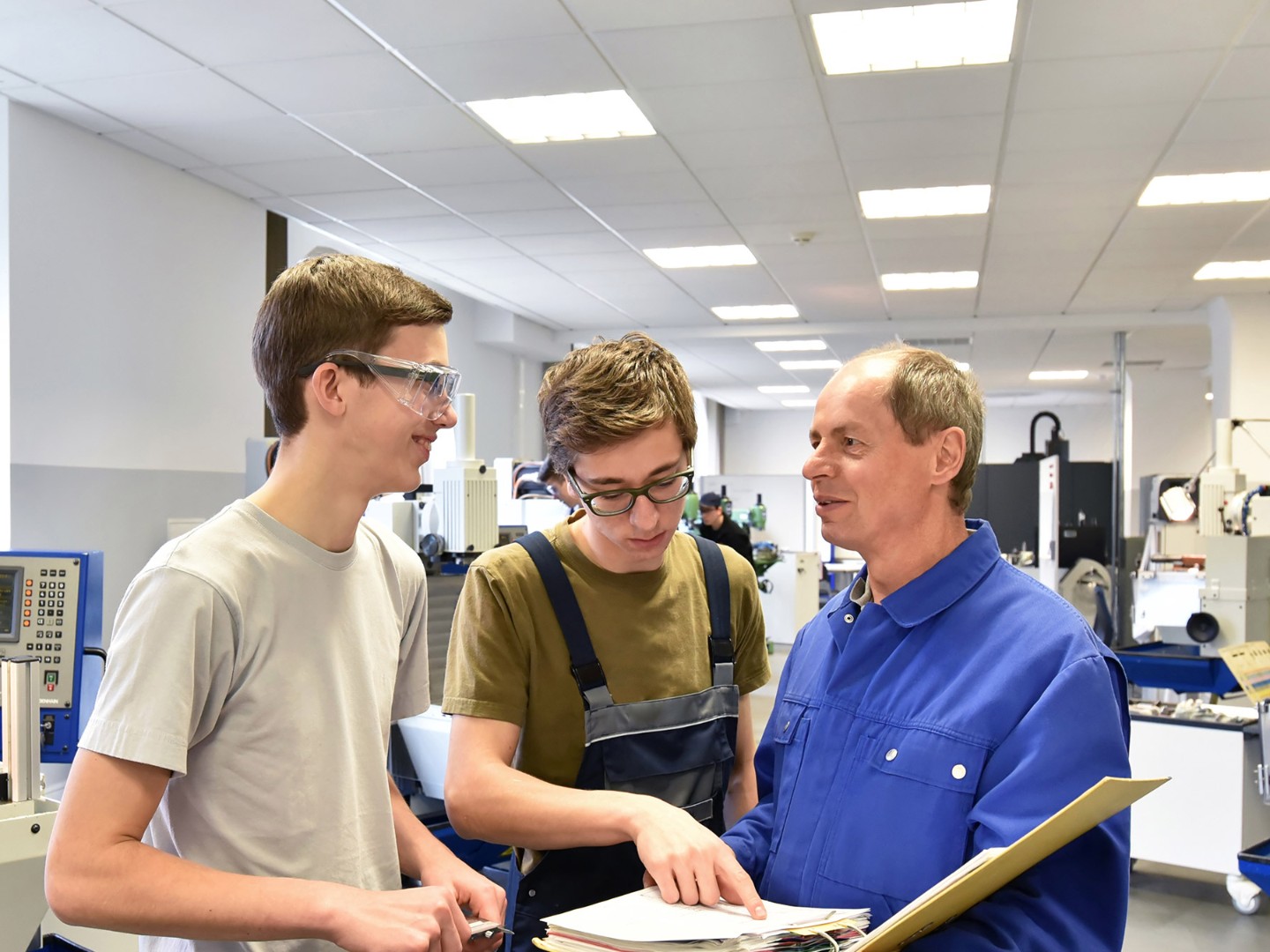 Gruppe von Jugendlichen in der technischen Berufsausbildung mit Lehrer
