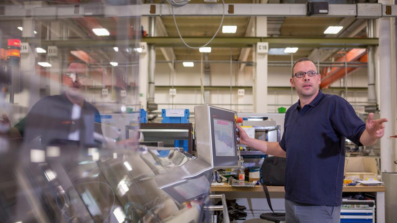 Ein Beschäftigter bedient eine CNC-Maschine