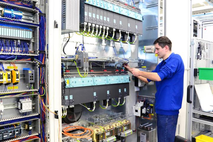 Ein junger Mann in der Produktion von Schaltschränken für Industrieanlagen.