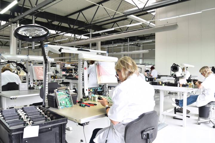 Frauen montieren Elektronik in einer Werkshalle.