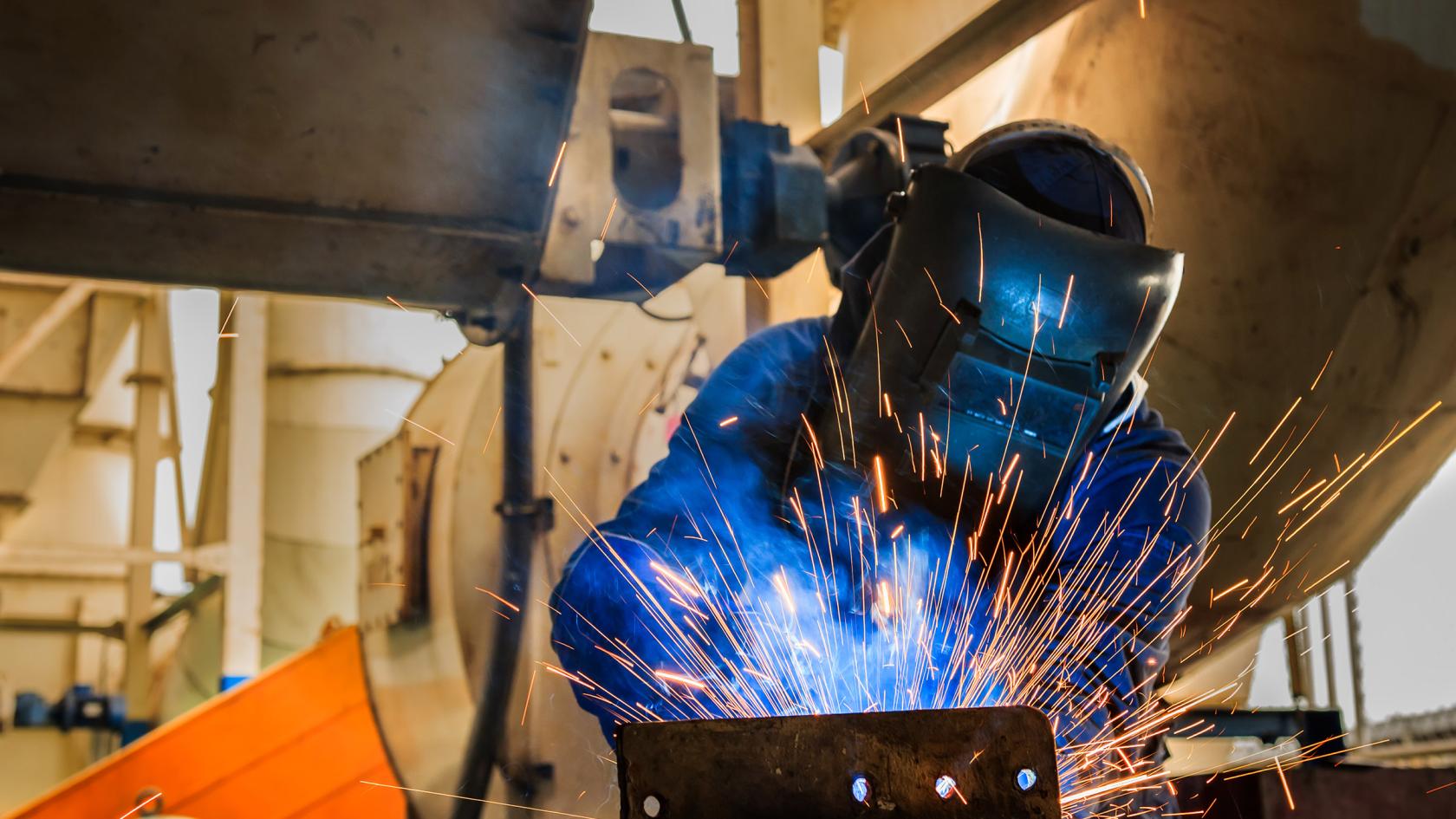 Industriearbeiter schweißt Montageteil in Fabrik