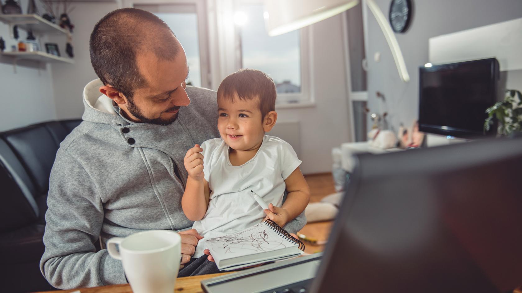 Vater spielt mit seinem Sohn vor dem Computer