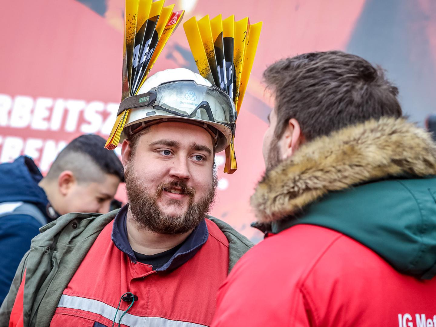 Stahlarbeiter spricht mit einem IG Metall Vertrauensmann während der Stahl-Tarifrunde in Duisburg