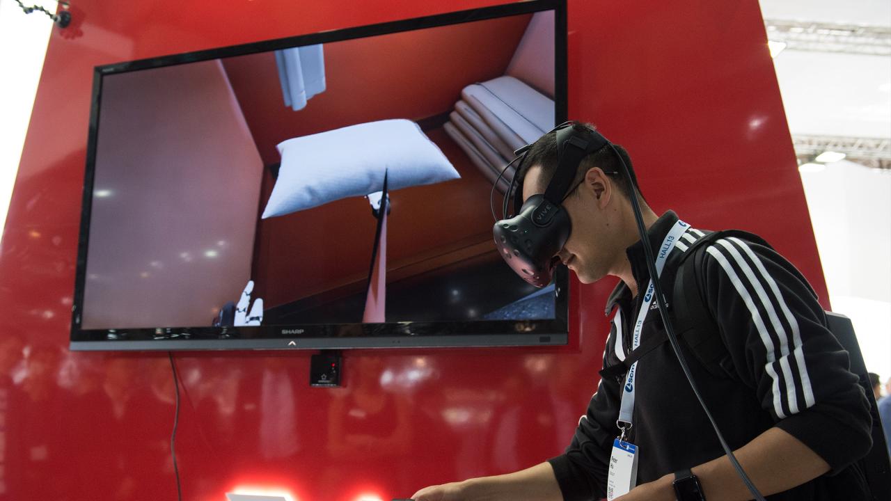 Mann auf der Messe Ligna mit virtual Reality Brille und Controllern