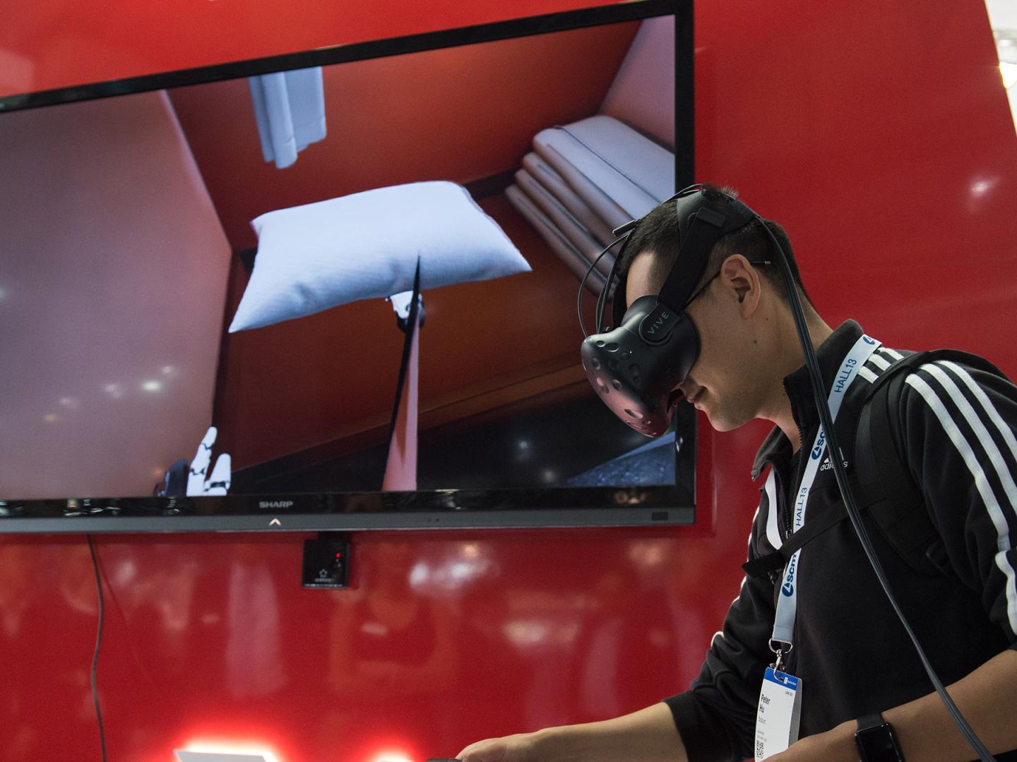 Mann auf der Messe Ligna mit virtual Reality Brille und Controllern