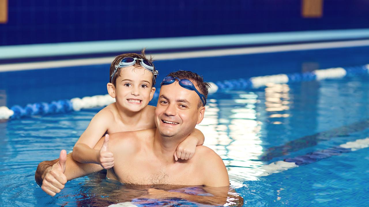 Junger Vater und seinem kleinen Sohn im Hallenbad 