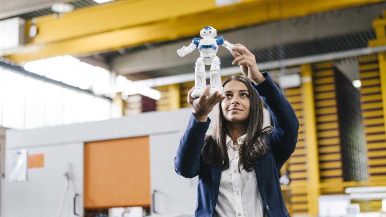 Junge Frau hält Mini-Roboter vor sich