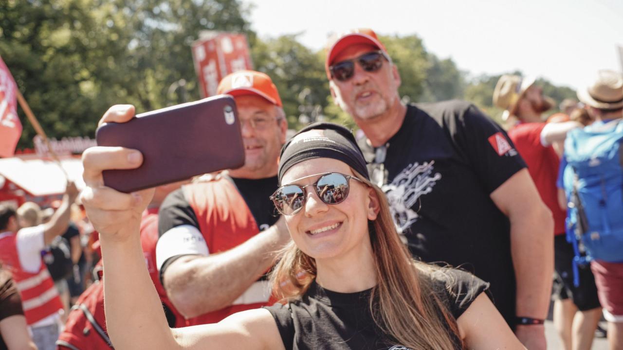 Metallerin schießt mit zwei Metallern ein Selfie-Foto auf der FairWandel-Kundgebung