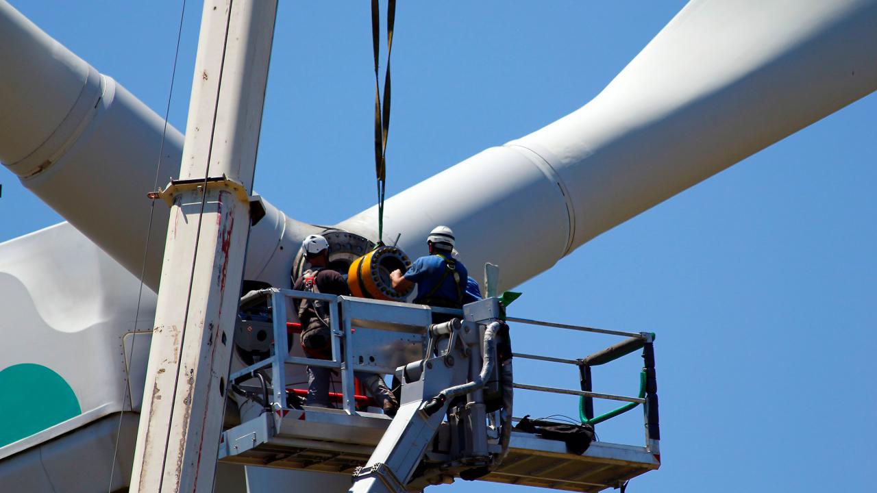 Zwei Techniker reparieren das Getriebe einer Windkraftanlage