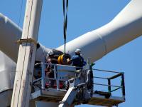Zwei Techniker reparieren das Getriebe einer Windkraftanlage