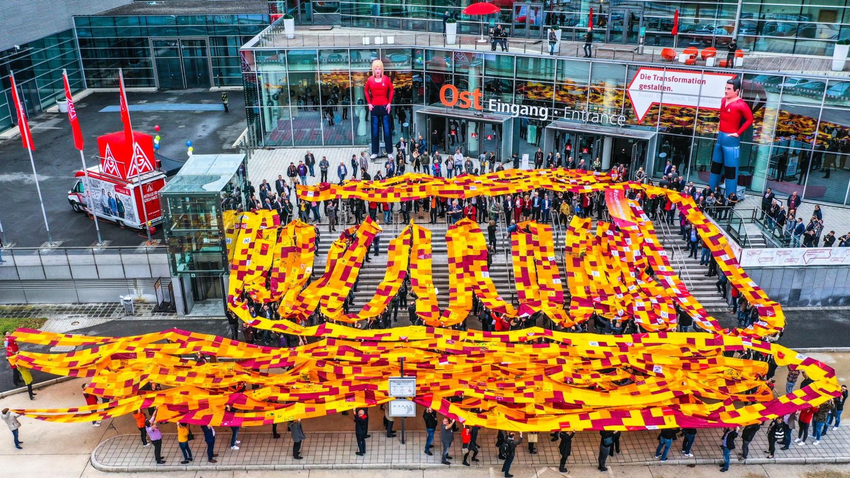 Delegierte des Gewerkschaftstages 2019 der IG Metall halten ein 600 Meter langes Banner gegen Rassismus