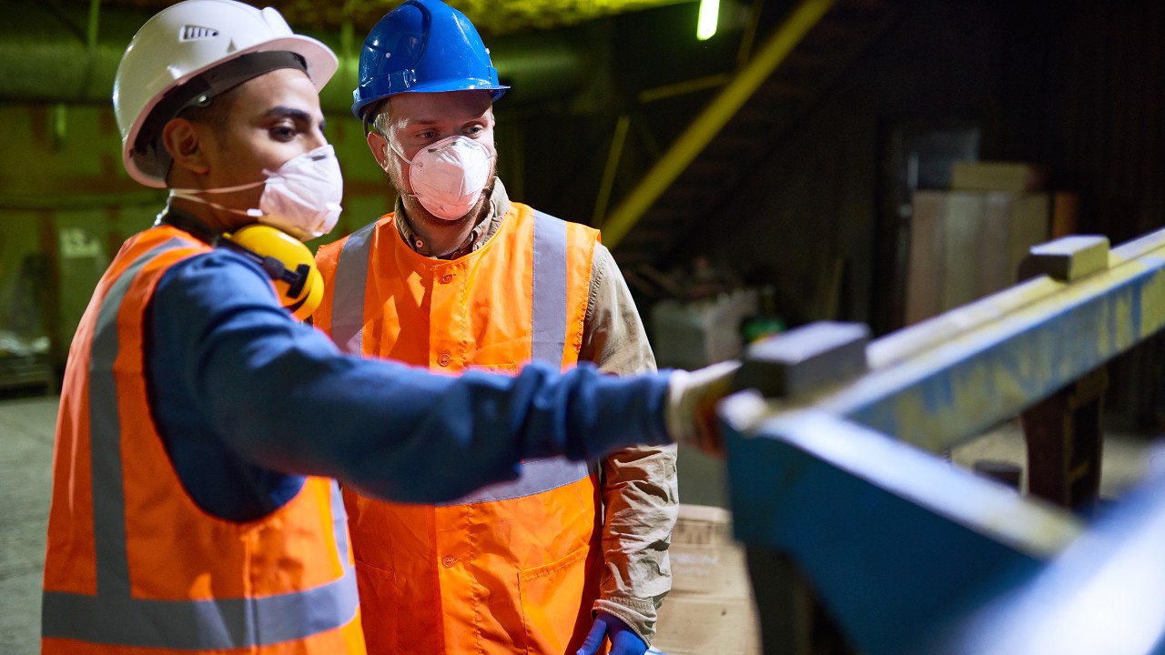 Arbeiter mit Schutzmaske in einem Metallbetrieb