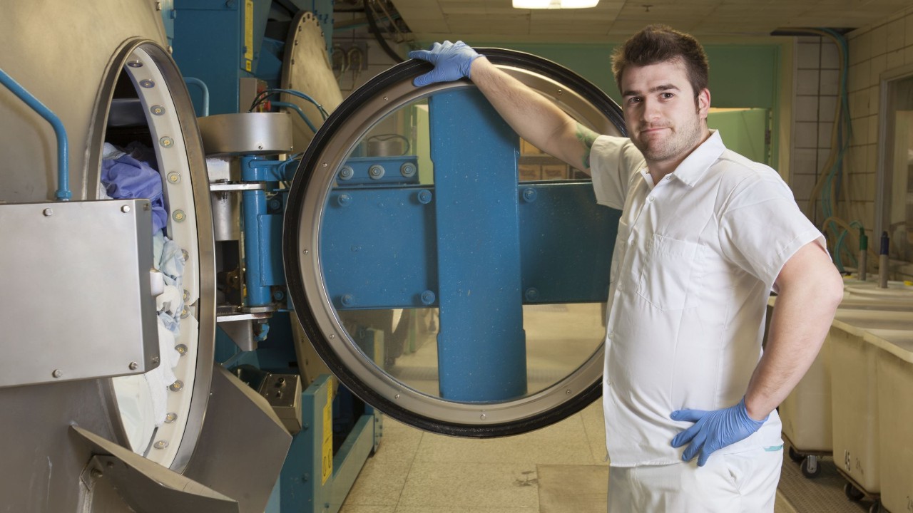 Arbeitnehmer an einer Waschmaschine in einer Wäscherei