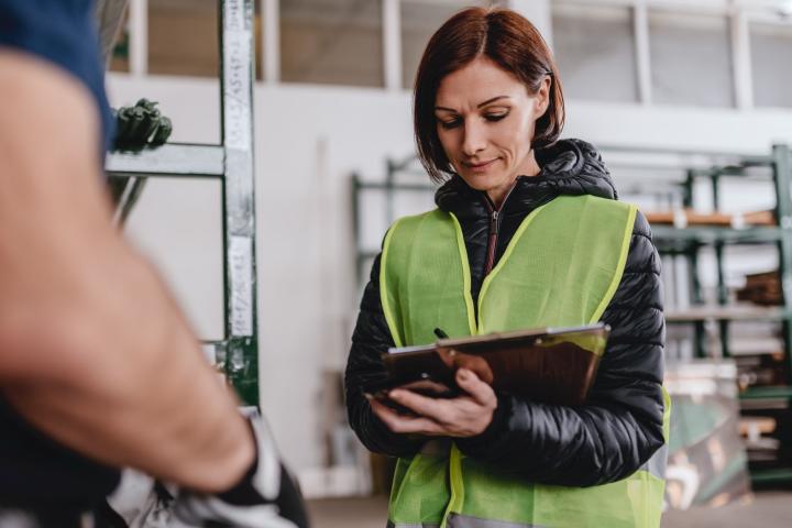 Arbeitnehmerin prüft Bestand in einem Lager