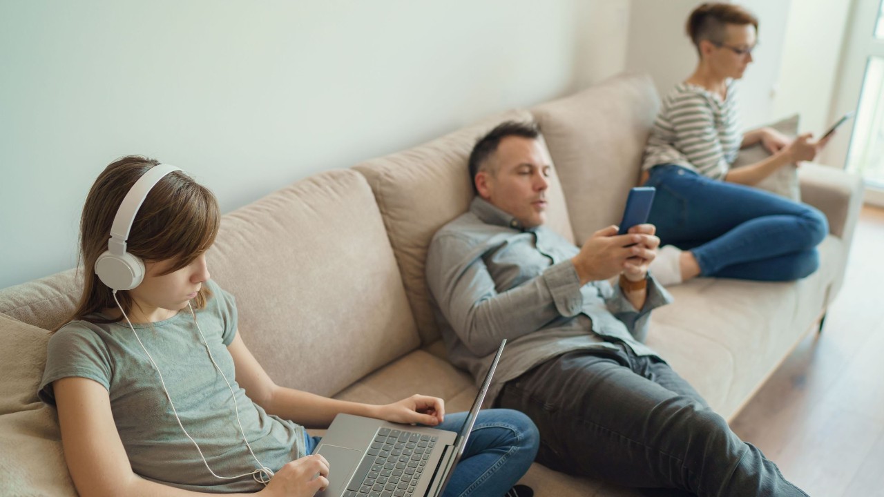 Familie sitzt gelangweilt auf dem Sofa