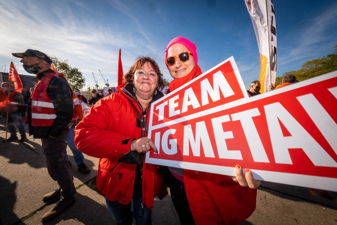 Zwei Metallerinnen mit Schild Team IG Metall in Hamburg beim Aktionstag Fairwandel.
