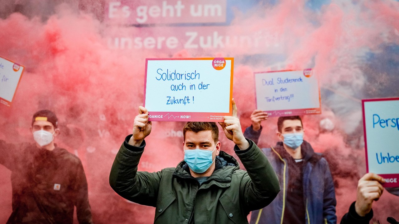 mit viel rotem Rauch macht die IG Metall Jugend auf ihre Forderungen aufmerksam.