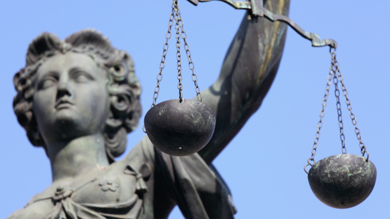 Eine Statue von Justizia mit Waage in der Hand