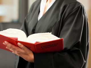 Eine Anwältin hält ein Gesetzbuch in der Hand