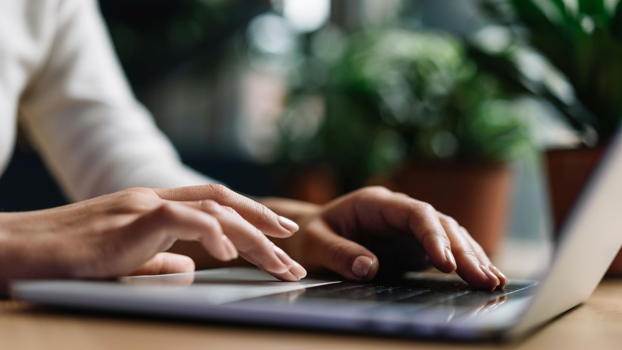 Hände tippen auf der Tastatur eines Laptops
