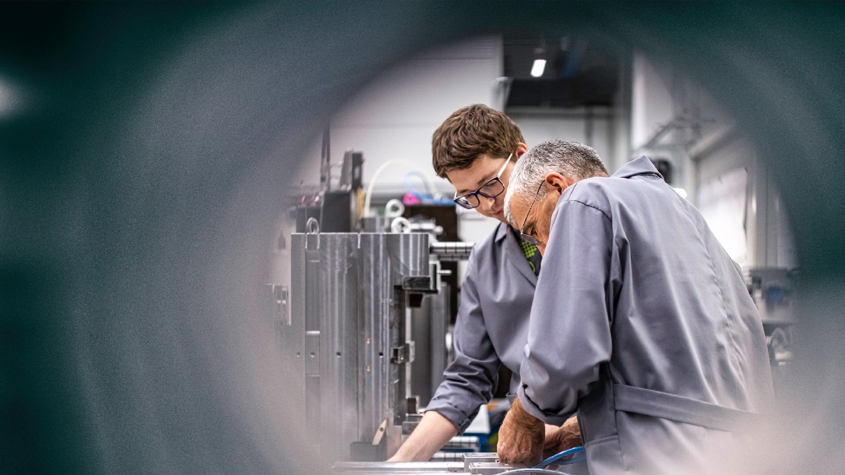 Ein älterer und ein jüngerer Arbeitnehmer in einem Betrieb.