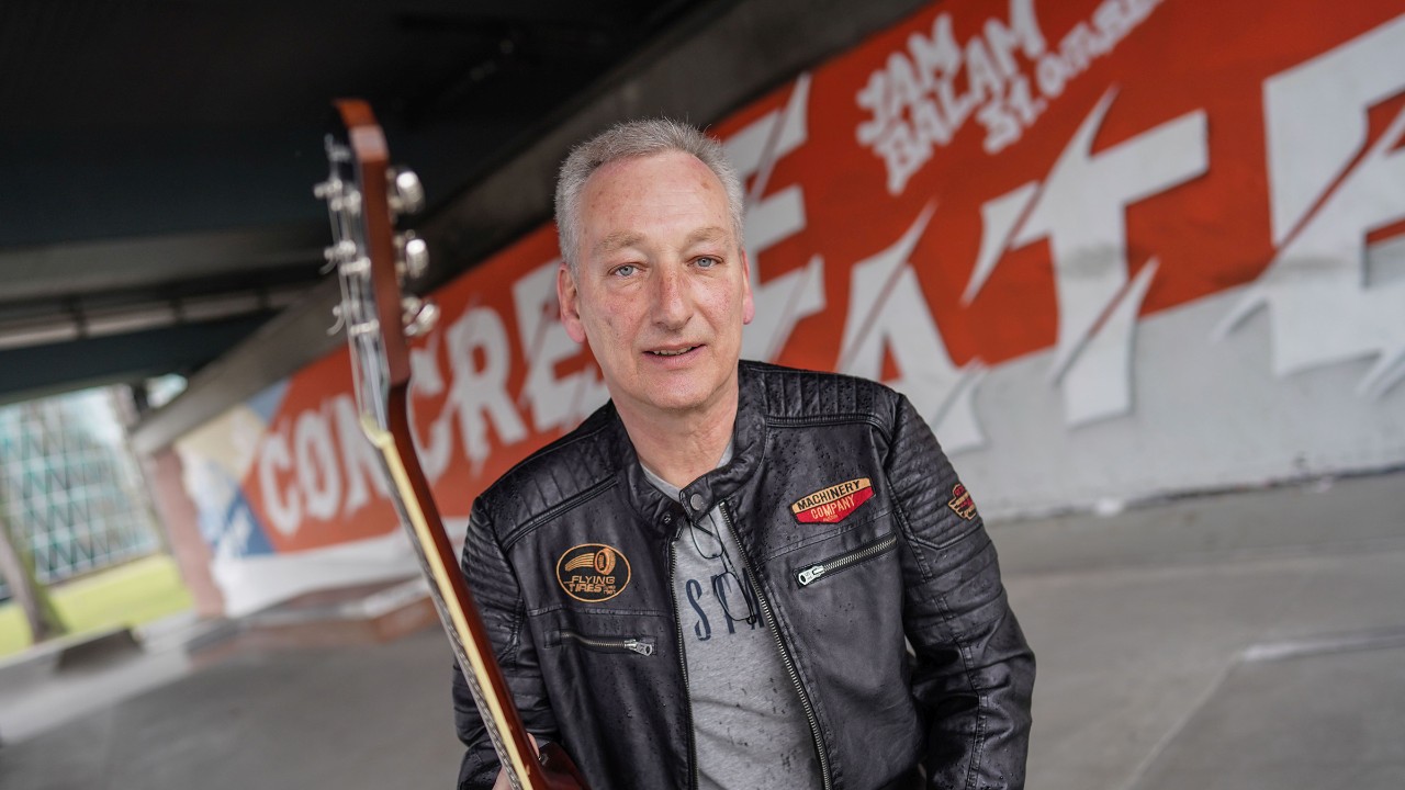 Der Sieger des IG Metall Fairwandel-Songwettbewerbs, Gunther Sanwald, mit seiner Gitarre