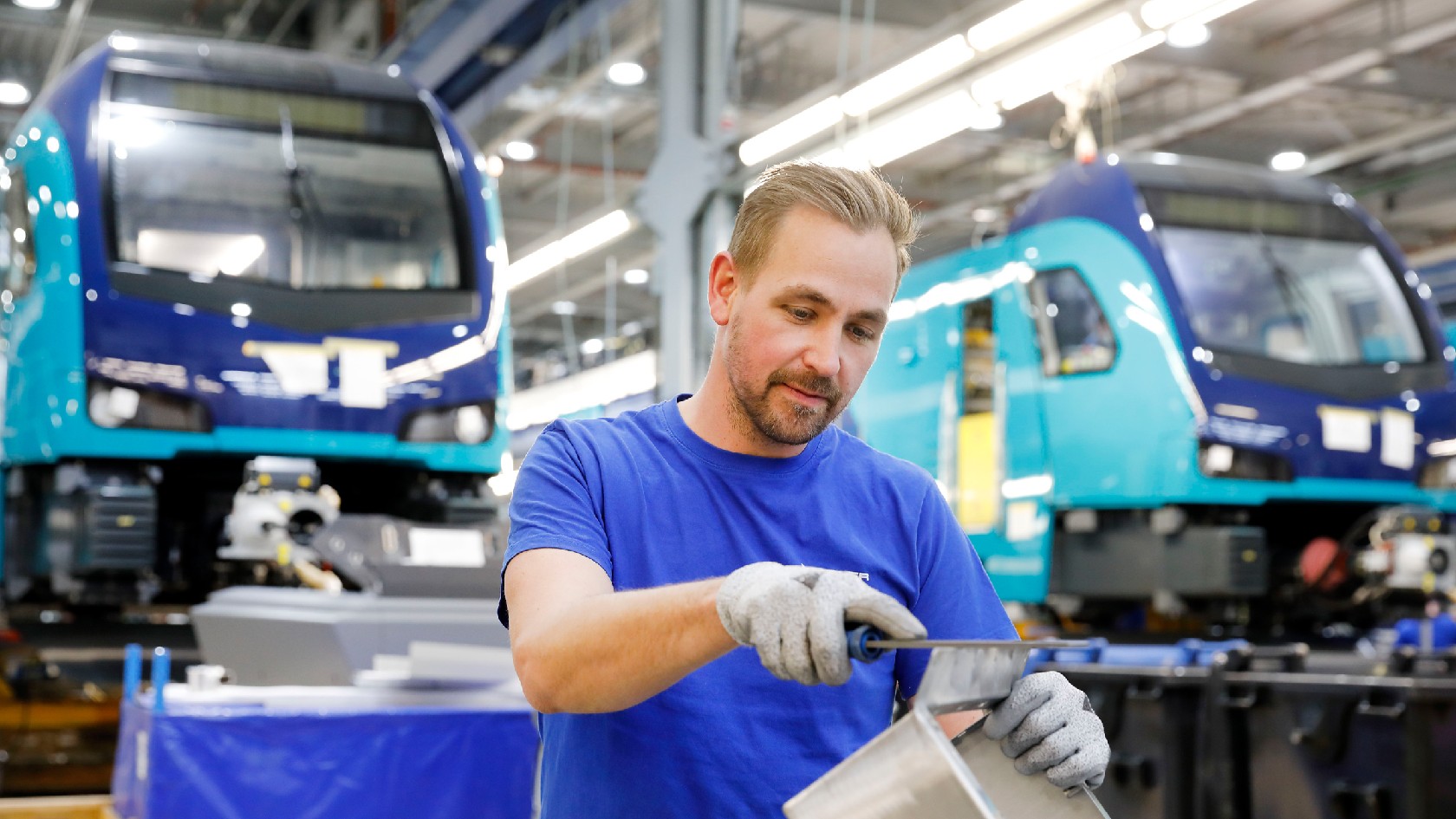 Daniel Simon feilt ein Metallteil bei Stadler in Berlin