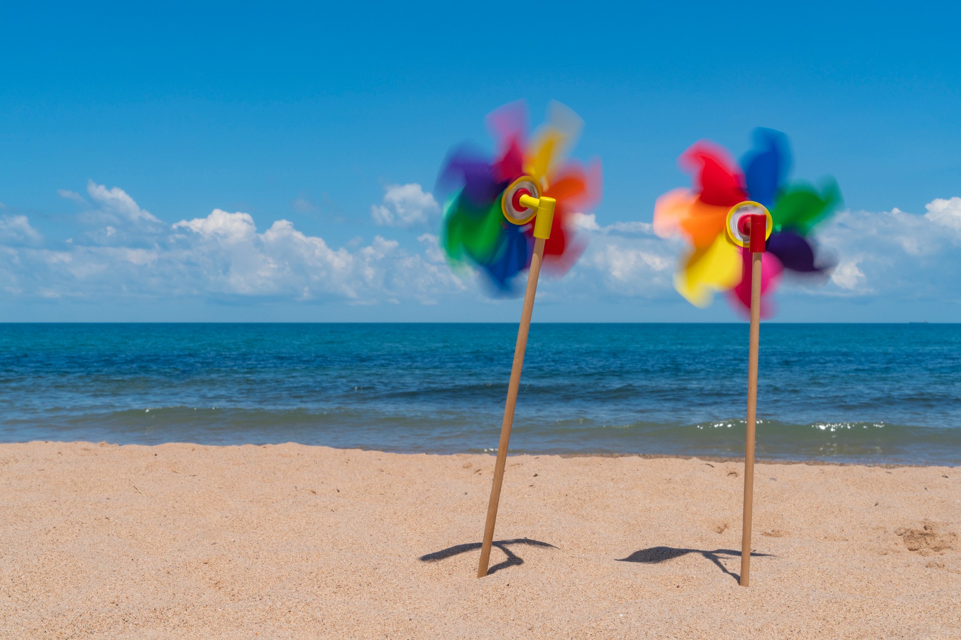 Meer, Strand und bunte Wetterfahne, Windräder.