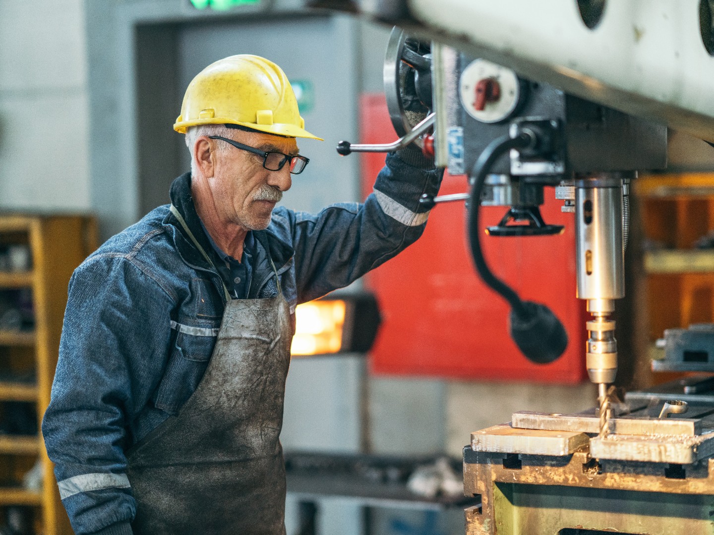 Arbeiter in einer Werkstatt an einer Bohrmaschine