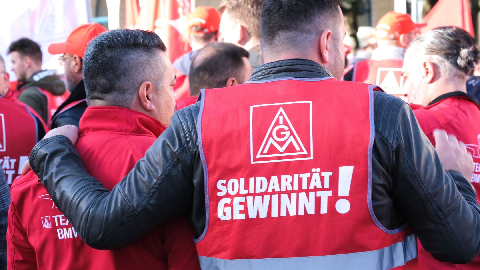 Ein Mann trägt bei einer Kundgebung eine Weste mit der Aufschrift „Solidarität gewinnt!“