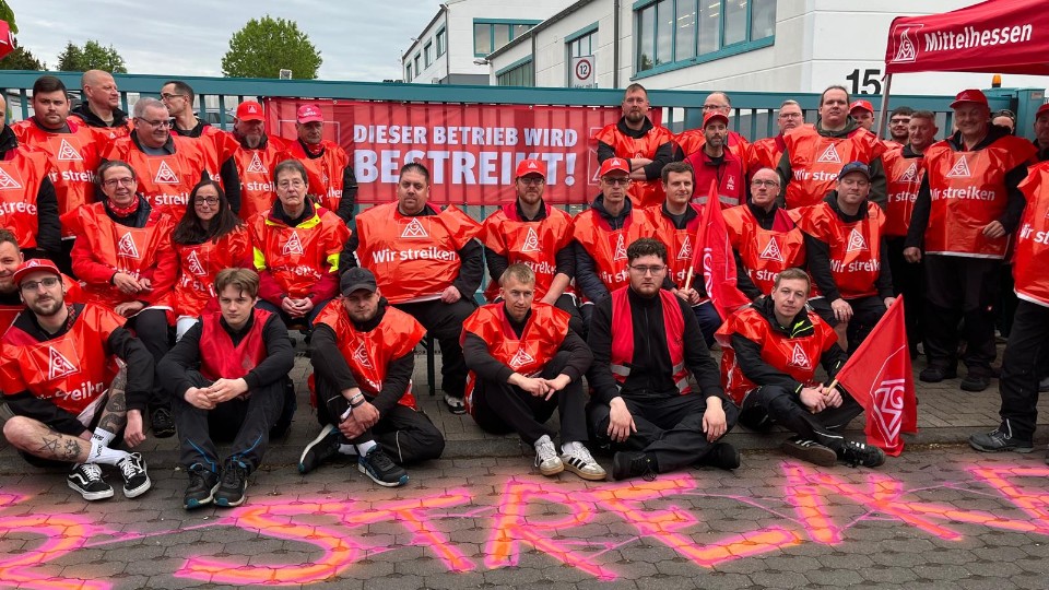 Gruppenfoto von Besch&auml;ftigten von Stanley Feinwerktechnik in Lahnau (Mittelhessen) in roten Streikwesten am zweiten Streiktag. 