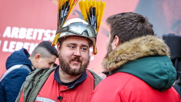 Stahlarbeiter spricht mit einem IG Metall Vertrauensmann während der Stahl-Tarifrunde in Duisburg