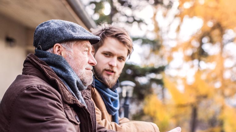 Vater und Sohn genießen zusammen den schönen Herbsttag auf dem Balkon