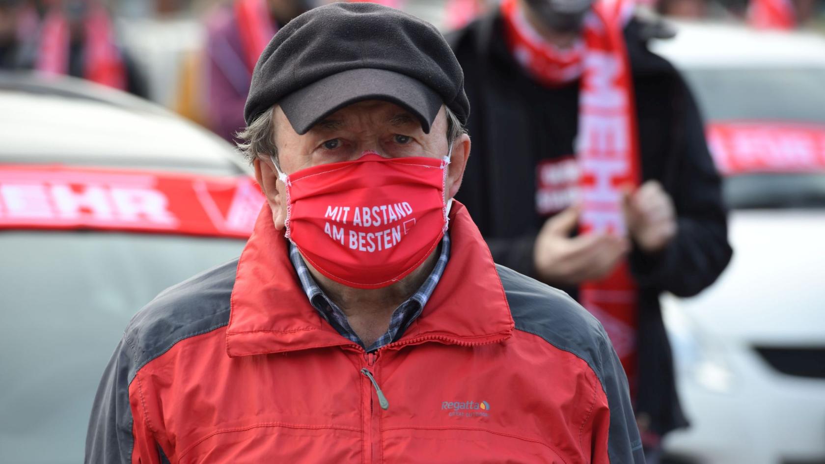 Metaller mit roter Maske demonstriert gegen Standortschließung Hitachi ABB in Hanau