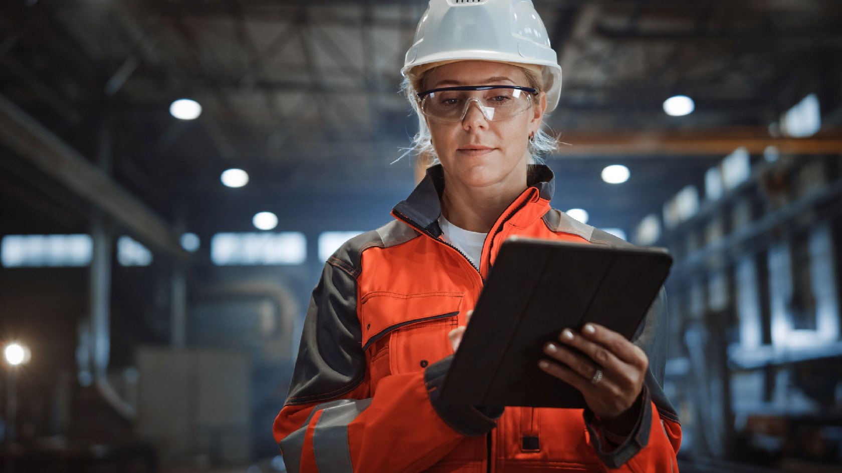 Arbeiterin mit Helm und Tablet