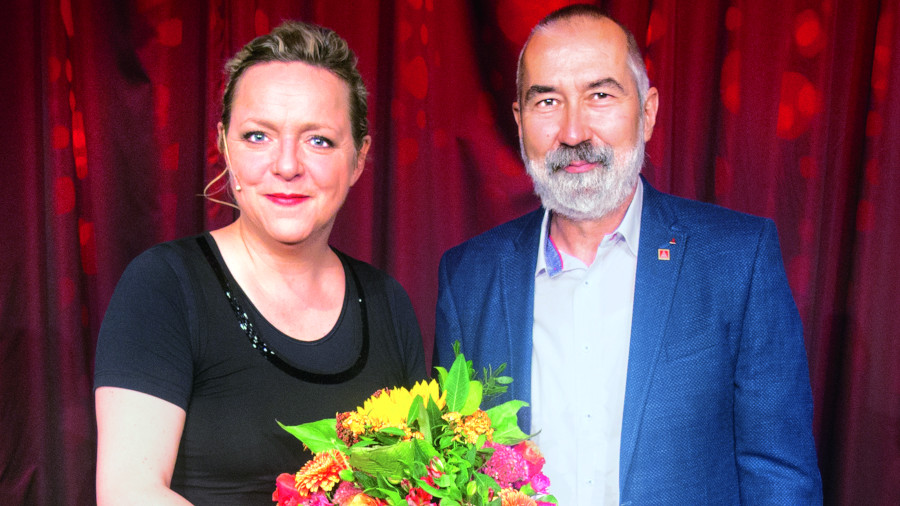 Kabarettistin Anke Geißler erhält nach ihrem Soloprogramm einen Blumenstrauß und einen kräftigen Applaus der Jubilare und Jubilarinnen als Dankeschön.