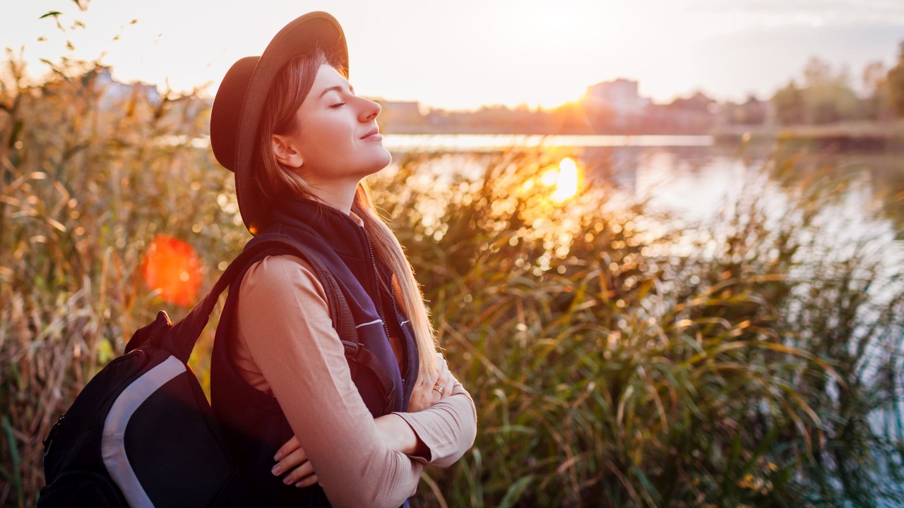 Junge Frau mit Rucksack am See