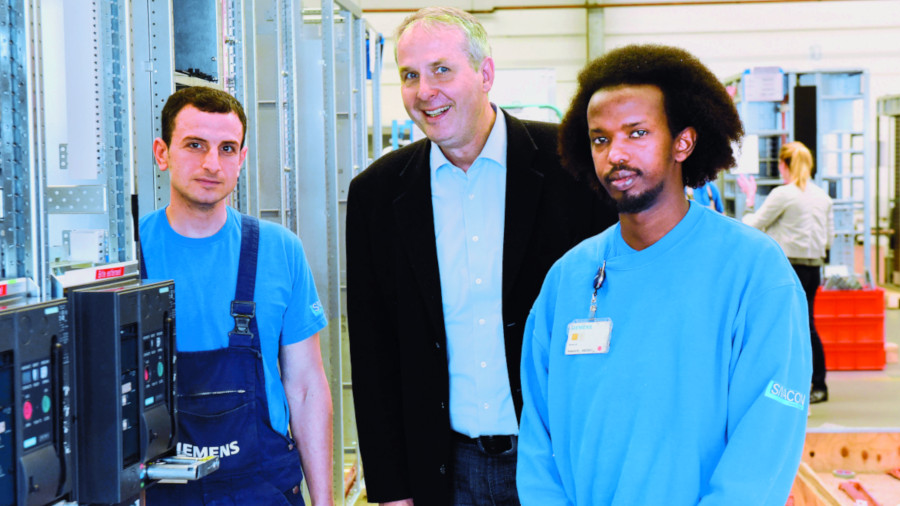 Der Preis für ein Integrationsprojekt ging an den Betriebsrat des Siemens-Schaltanlagenwerks Leipzig: zwei Geflüchtete mit Betriebsrat Michael Hellriegel.