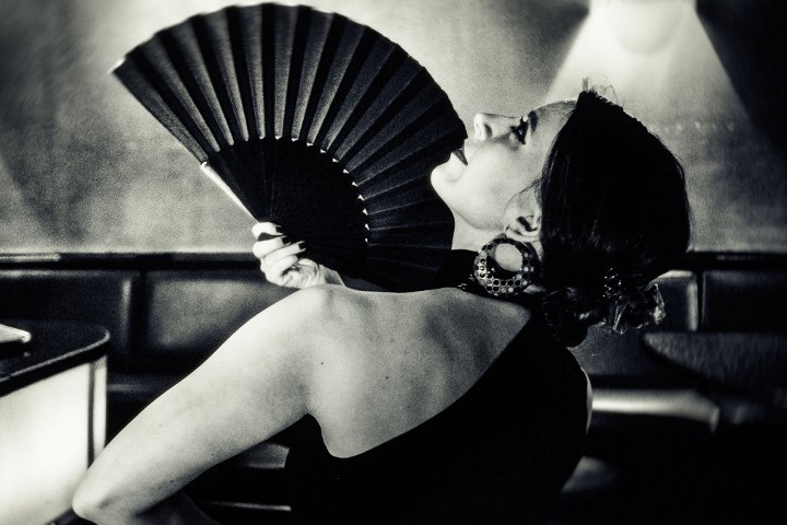 Eine Flamenco-Tänzerin posiert mit Fächer